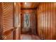 A view of a bedroom closet with louvered doors and a window showcasing trees at 7016 Evanston Ave, Indianapolis, IN 46220