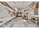 View of a spacious garage with concrete floors, workbenches, and fluorescent lighting at 7016 Evanston Ave, Indianapolis, IN 46220