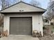 Detached garage with a weathered exterior, a large door, and concrete floor at 7016 Evanston Ave, Indianapolis, IN 46220