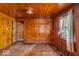 This living room features wood paneled walls and ceiling, plus natural light from a window at 7016 Evanston Ave, Indianapolis, IN 46220