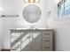 Sunlit bathroom vanity with marble countertop, round mirror, and brass fixtures at 7844 N Audubon Rd, Indianapolis, IN 46250
