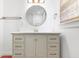 Bright bathroom vanity with a round mirror, brass fixtures, and a light-toned finish at 7844 N Audubon Rd, Indianapolis, IN 46250