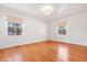 Bright bedroom with hardwood floors, two windows, a modern light fixture and painted white walls at 7844 N Audubon Rd, Indianapolis, IN 46250