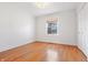 Bedroom with hardwood floors, a window with blinds, and a closet with white doors at 7844 N Audubon Rd, Indianapolis, IN 46250