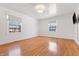Bright bedroom with hardwood floors, two windows, a modern light fixture and painted white walls at 7844 N Audubon Rd, Indianapolis, IN 46250