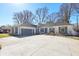 Wide driveway leads to a painted brick house with an attached garage and shutters at 7844 N Audubon Rd, Indianapolis, IN 46250