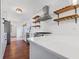 Bright kitchen boasts white cabinets, marble countertops, stainless steel appliances, open shelving, and hardwood floors at 7844 N Audubon Rd, Indianapolis, IN 46250