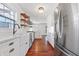 Modern kitchen with white cabinets, stainless steel appliances, and hardwood floors at 7844 N Audubon Rd, Indianapolis, IN 46250