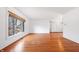 Bright living room with hardwood floors, white walls, and a large window overlooking the yard at 7844 N Audubon Rd, Indianapolis, IN 46250