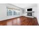 Bright Living Room boasts dark hardwood floors, large windows, white walls, and cozy fireplace at 7844 N Audubon Rd, Indianapolis, IN 46250