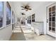 A screened porch featuring paneled walls, ceiling fans, and large windows for natural light at 7844 N Audubon Rd, Indianapolis, IN 46250