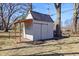 A well-maintained shed with a sliding door, wooden awning, and organized surroundings at 7844 N Audubon Rd, Indianapolis, IN 46250