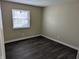 Empty bedroom offers neutral color walls, updated flooring, and a large window at 8002 Bryan Dr, Indianapolis, IN 46227