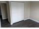 Bedroom with neutral walls, dark wood-look flooring, and a closet with bi-fold doors at 8002 Bryan Dr, Indianapolis, IN 46227