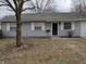 The house has a small yard and a classic front door with white trim at 8002 Bryan Dr, Indianapolis, IN 46227