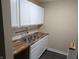 Renovated kitchen with stainless steel sink and white cabinets offers ample storage space at 8002 Bryan Dr, Indianapolis, IN 46227