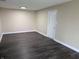 Room with neutral colored walls, base trim, ceiling light, and dark wood-look flooring at 8002 Bryan Dr, Indianapolis, IN 46227