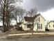 Street view of the two-story house with a brown roof and a quaint front porch lined by barren trees at 804 N Jameson St, Lebanon, IN 46052