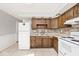 Traditional kitchen with wood cabinets, stainless steel sink, stone backsplash, and white appliances at 8139 Laughlin Dr, Indianapolis, IN 46219