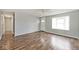 Open-concept living room with wood-look floors, large window, and view into hallway at 8139 Laughlin Dr, Indianapolis, IN 46219