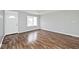 Cozy living room with wood-look flooring, bright natural light from window, and a view of the front door at 8139 Laughlin Dr, Indianapolis, IN 46219