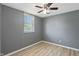 Bedroom featuring light wood floors, gray walls, a ceiling fan, and a bright window at 818 S Grant St, Muncie, IN 47302