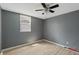 Cozy bedroom featuring light wood floors, gray walls, a ceiling fan, and a window at 818 S Grant St, Muncie, IN 47302