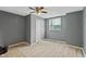 Bedroom featuring light wood floors, gray walls, a ceiling fan, and natural light from a window at 818 S Grant St, Muncie, IN 47302