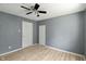 Bedroom featuring light wood floors, gray walls, a ceiling fan, and two white doors at 818 S Grant St, Muncie, IN 47302