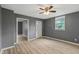 Inviting room featuring light wood floors, gray walls, a ceiling fan, and a white entry door at 818 S Grant St, Muncie, IN 47302