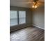 Well-lit bedroom featuring vinyl flooring, large windows, and a ceiling fan for comfort at 8249 Retreat Ln, Indianapolis, IN 46259
