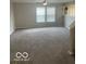 Spacious carpeted living room with ceiling fan and bright natural light from two windows at 8249 Retreat Ln, Indianapolis, IN 46259