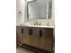 Stylish bathroom with a wood vanity, black fixtures, and a sleek, modern mirror at 8315 Woodall Dr, Indianapolis, IN 46268
