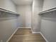 Walk-in closet with white shelving and neutral-toned wood floors at 8315 Woodall Dr, Indianapolis, IN 46268