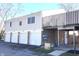 A townhome exterior featuring a row of garages and a private balcony overlooking a landscaped yard at 8315 Woodall Dr, Indianapolis, IN 46268