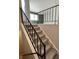 Carpeted stairway with sleek black railing leads to an open living area with natural light at 8315 Woodall Dr, Indianapolis, IN 46268