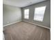 This carpeted bedroom features two bright windows with horizontal blinds and neutral walls at 9616 Beckett St, Avon, IN 46123