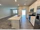 Open-concept kitchen with stainless steel appliances and a center island, seamlessly connected to the living area at 9616 Beckett St, Avon, IN 46123
