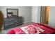 Bright bedroom featuring gray wood furniture and a comfortable bed with a floral blanket at 10218 Cliff Ln, Indianapolis, IN 46239