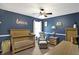 Bedroom with blue walls, a wood crib, a chair and ottoman, and a side table at 11185 Beardsley Way, Fishers, IN 46038