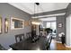 Elegant dining room with dark wood table, hardwood floors, contemporary lighting, and view into living room at 11185 Beardsley Way, Fishers, IN 46038