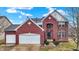 Charming two-story red brick home with a two-car garage and well-maintained front yard at 11185 Beardsley Way, Fishers, IN 46038