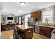 Modern kitchen with stainless steel appliances, island seating, and seamless flow to the living area at 11185 Beardsley Way, Fishers, IN 46038