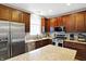 Well-lit kitchen featuring granite countertops, stainless steel appliances, and wood cabinetry at 11185 Beardsley Way, Fishers, IN 46038