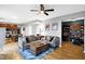 Spacious living room with hardwood floors, neutral paint, a leather sofa, and views into other rooms at 11185 Beardsley Way, Fishers, IN 46038