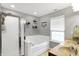 Bright main bathroom with a soaking tub, glass-enclosed shower, and double sink vanity at 11185 Beardsley Way, Fishers, IN 46038
