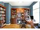 Office space with custom built-in shelving, hardwood floors, and an executive desk at 11185 Beardsley Way, Fishers, IN 46038