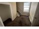 Hallway with carpet floors and neutral walls features access to the staircase and is near a window at 1153 Villa Ave, Indianapolis, IN 46203