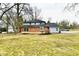 View of the house and backyard, with a deck, well-maintained lawn, and mature trees at 11708 Rolling Springs Dr, Carmel, IN 46033