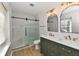 Bathroom featuring a glass-enclosed shower, double sink vanity, and wood-look tile flooring at 11708 Rolling Springs Dr, Carmel, IN 46033